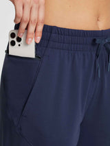 Women's navy fleece joggers with zippered side pocket for phone. #color_Navy Blue