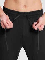 Close-up of hands adjusting the drawstring on black men's reflective fleece jogger pants #color_Black