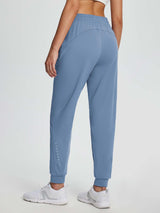 Women's blue fleece-lined jogger pants with elastic waist, pockets, and reflective ankle detail.