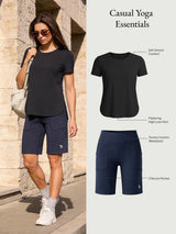 Casual yoga outfit: woman in black soft stretch tee and navy Bermuda shorts with tummy control waistband and pockets.