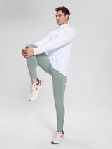 Men's 30" fleece-lined cycling tights in light green with reflective details, shown on a model stretching. #color_Gray