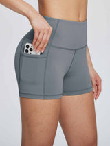 Gray high-waisted biker shorts with pockets for phone, showcasing compression fabric and seamless design. #color_Dark Gray
