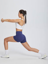 Navy blue women's 3" high-waisted compression biker shorts with tummy control, in lunge pose. #color_Navy Blue