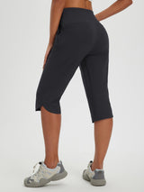 Women's 17-inch dark grey hiking capris featuring a curved hem and athletic shoes. #color_Black