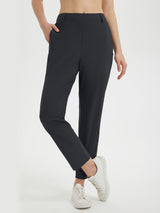 Woman wearing black Baleaf 27" golf pants with a flexible waistband and white sneakers. #color_Black