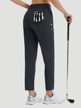 Women's 27" golf pants in dark gray with a golf glove in the back pocket. #color_Black