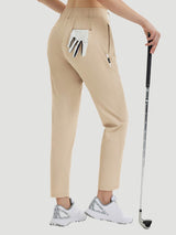Woman wearing khaki 27" golf pants with a golf glove in the back pocket and holding a golf club. #color_Khaki