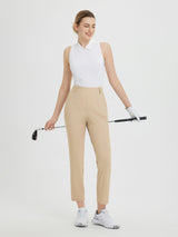 Woman in tan Baleaf 27" golf pants and white sleeveless polo, holding a golf club and wearing a golf glove. #color_Khaki