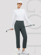 Woman in dark gray 27" golf fleece straight-leg pants, white top, and cap, holding golf club. #Color_Dark Gray