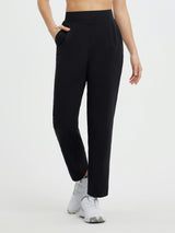 Women's black pleated fleece slim-fit golf pants with pockets and white athletic shoes. #color_Black