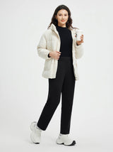 Woman in cream puffer jacket and black golf pants holding coffee cup. #color_Black