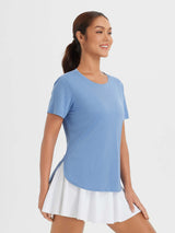 Light blue women's outdoor short sleeve tee with high-low hem, paired with white skort. #color_Heather Light Blue