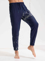 Men's navy blue woven hiking joggers with water beading off the fabric, showing water-resistant properties. #color_Navy Blue