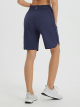 Navy blue women's 9" high-waisted running shorts with curved hem and side zipper pockets. #color_Navy Blue