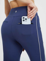 Dark blue fleece-lined joggers with zippered pocket holding a smartphone and white side stripe detail. #color_Blue/White
