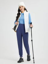 Woman in fleece-lined joggers with a vest and trekking pole, ready for outdoor activity. #color_Blue/White