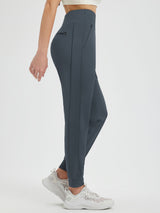 Woman wearing charcoal gray fleece-lined running joggers with zippered pocket and cuffed ankles. #color_Charcoal Gray