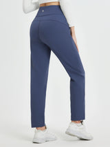 Women's navy blue thermal fleece running pants with a tapered leg and white sneakers. #color_Navy Blue