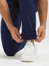 Men's navy blue dual-pocket fleece tapered pants with a visible thermal lining at the cuff. #color_Navy Blue