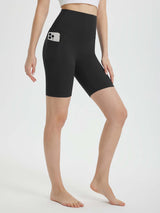 Woman in black 8" super high-waisted biker shorts with a phone in the side pocket #color_Black