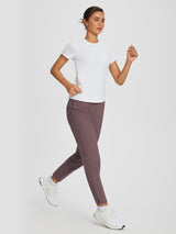 Woman in white t-shirt and mauve tapered yoga pants running. #color_Dark Brown
