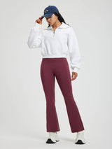 Woman in maroon floral fleece flare yoga pants and white zip-up sweatshirt, with NY cap. #color_Wine Red