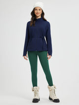 Navy fleece jacket with drawstring, green leggings, white beanie, and fur boots.