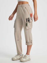 Baleaf tan ripstop hiking pants, capri length, with multiple cargo pockets and outdoor gear. #color_Khaki