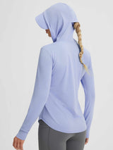 Woman from back in light blue UPF 50+ casual trail hooded jacket with visor, grey leggings. #color_Blue