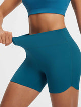 Baleaf teal 5" high-rise biker shorts with stretchy fabric and curved split hem. #color_Deep Blue