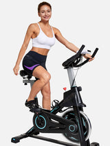 Woman cycling in black V-waist shorts with purple accents and a white sports bra. #color_Purple