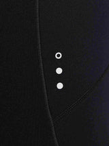 Close-up of black women's fleece-padded cycling tights, showing ribbed texture and reflective dots. #color_Black