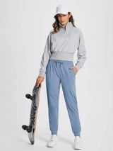 Women's blue fleece jogger pants with drawstring waistband, model holding skateboard. #color_Light Blue
