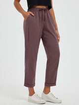 Plum straight-leg outdoor hiking pants with zippered thigh pocket and cuffed hem.