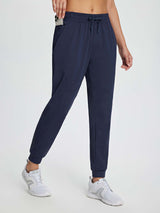Women's navy fleece joggers with drawstring, elastic waist, and side pockets for warmth and utility. #color_Navy Blue