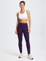 Woman wearing dark purple running fleece waterproof skinny leggings and a white sports bra. #color_Dark Purple