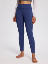 Woman wearing navy blue petite fleece-lined yoga leggings with a high waistband. #color_Navy Blue