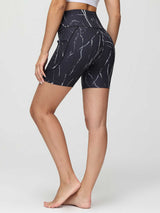 Women's black 6" high-waisted yoga shorts with a white marble print and side pockets.