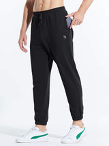 Men's black cotton joggers with phone pocket, drawstring, and cuffed ankles, paired with white sneakers. #color_Black/Blue