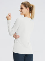 Woman wearing a light gray long sleeve rash guard, showing a relaxed fit and comfortable fabric. #color_White