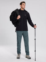 Man in black jacket and teal elastic waist fleece mountain pants, with backpack & pole. #color_Dark Gray