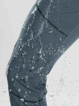 Water beads on water-resistant dark gray fleece mountain pants.