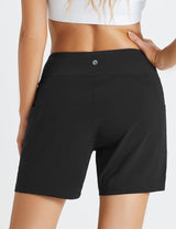 Back view of woman wearing black Laureate women's 5" high-waisted swim shorts with pockets. #color_Black