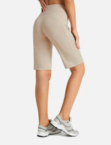 Flyleaf Women's 12" high-waisted beige running shorts with side pockets, paired with grey sneakers.