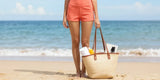 A woman relaxing at the beach wearing fashionable swim board shorts