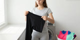 Woman turning yoga pants inside out before washing activewear laundry carefully