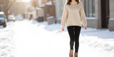 Stylish woman wearing black fleece lined leggings women walking in winter city.