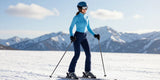 Woman wearing waterproof ski pants and base layer on snowy mountain slope ready for winter sports