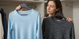 Woman comparing modal vs merino wool fabric textures in closet