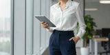 Professional woman wearing navy travel pants women in a modern office setting